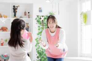 笑顔で子どもと遊ぶ保育士　