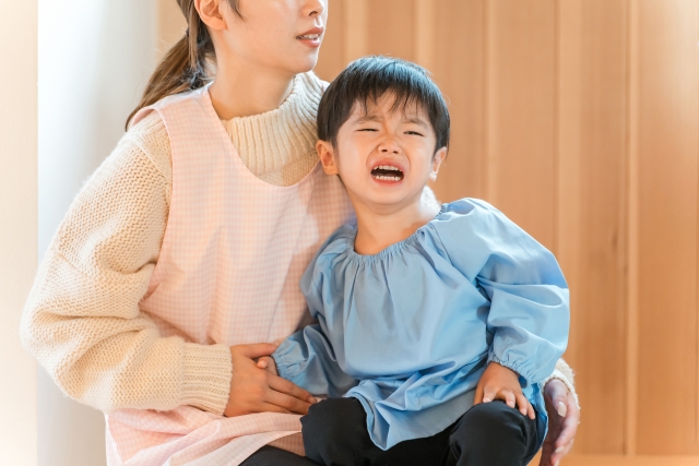 泣いている子どもに寄り添う保育士