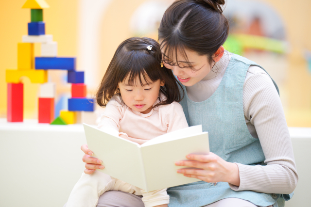 絵本を子どもに読む実習生