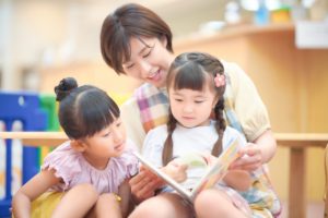 絵本を読む保育士と子ども