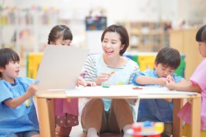 製作をする保育士と園児