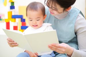 絵本を読む保育士と子ども