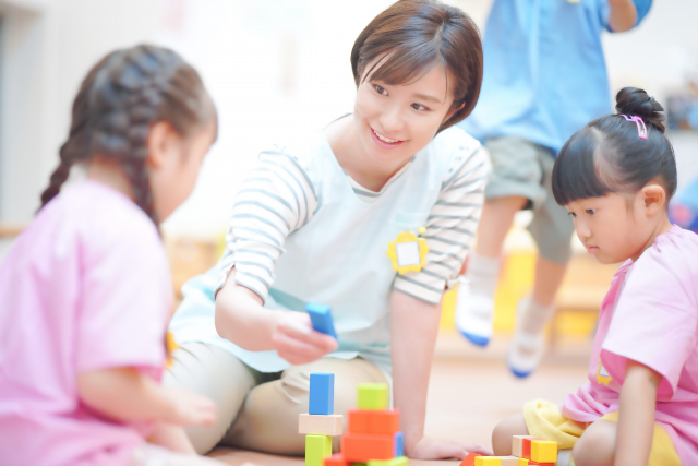 子どもと遊ぶ保育者