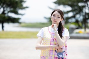 あごに手を当てて悩んでいるエプロン姿の保育士