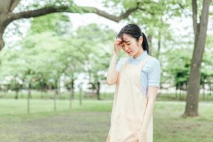 エプロン姿の保育士　頭を抱える　しんどい