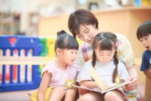 絵本を読む保育士と子ども