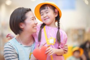 子どもと保育士が笑顔で見つめ合う